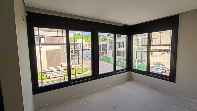 Esquadria de canto com janelas de alumínio preto em imóvel em obra
