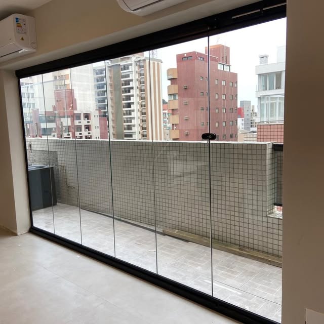 Painel grande de vidro de correr com perfil preto e vista da cidade